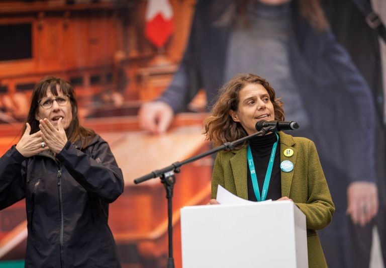 Felicitas Huggenberger et une interprète en langue des signes lors d'un discours sur la Place fédérale